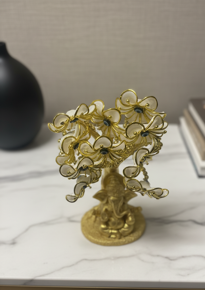 Decorative gold tree sculpture on a marble surface with a neutral background
