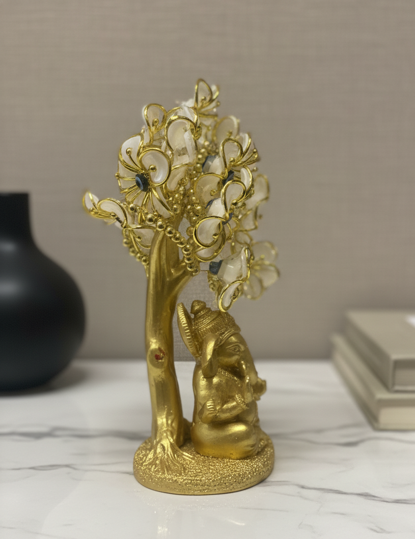 Gold decorative statue with a face and floral elements on a marble surface.